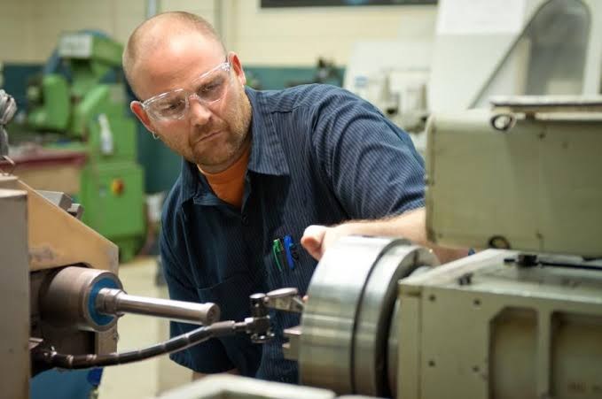Un technicien contrôle une machine dans l'atelier.